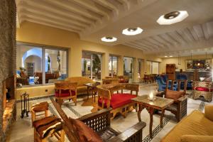 sala de estar con mesas, sillas y ventanas en Ksar Anika Boutique Hotel & Spa, en Marrakech