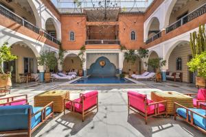 馬拉喀什的住宿－Ksar Anika Boutique Hotel & Spa，一个带桌椅的庭院和一个游泳池