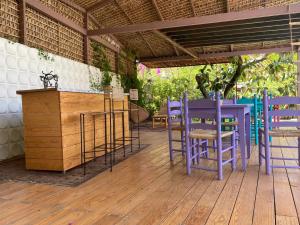 a deck with purple chairs and a wooden table at Villa Coiros ECOFRIENDLY suites & villas in Tonatico