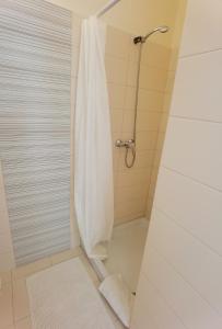 a shower with a white shower curtain in a bathroom at Cuvi Studio S in Rovinj