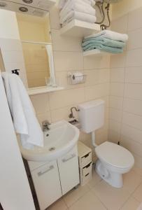 a bathroom with a white sink and a toilet at Cuvi Studio S in Rovinj