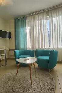 a living room with a blue couch and a table at Cuvi Studio S in Rovinj