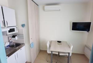 a kitchen with a table and chairs in a room at Cuvi Studio S in Rovinj