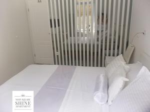 a bed with white sheets and pillows in a room at Luxurios and historic apartment "Shine" - right on the Main Square in Zagreb