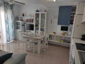 een woonkamer met een tafel en stoelen en een keuken bij Apartamento con piscina en primera linea de playa in Puerto de Mazarrón