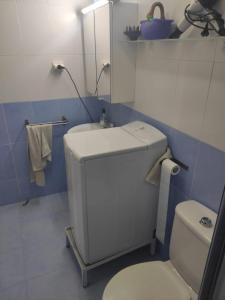 een badkamer met een wit toilet en een wastafel bij Apartamento con piscina en primera linea de playa in Puerto de Mazarrón