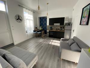 sala de estar con sofá y cocina en Appartement Centre ville Louviers, en Louviers