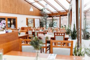 an empty restaurant with wooden tables and chairs at Akzent Hotel Zur Grünen Eiche in Bispingen