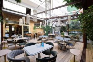 a restaurant with tables and chairs and windows at John's Hotel in Chalkida