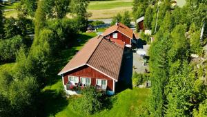 a house with a brown roof on a green field at Kullerbacka Gästhus in Segersta