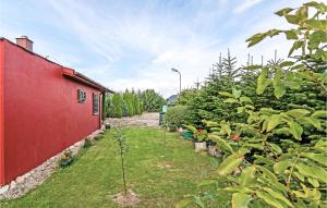 a garden with trees and a red building at 1 Bedroom Gorgeous Home In Mscice in Mścice