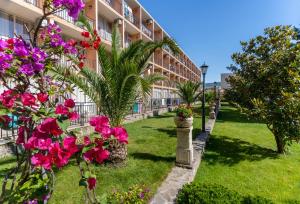einen Innenhof eines Gebäudes mit Blumen und Pflanzen in der Unterkunft Hotel Riva - All Inclusive in Sonnenstrand