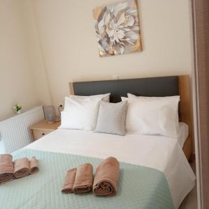 Un dormitorio con una cama blanca con toallas. en AVELLANA ROYAL SUITES, en Leptokarya