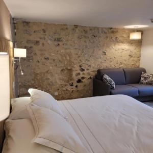 1 dormitorio con 1 cama y 1 sofá en Hôtel Restaurant Le Lachens, en La Bastide