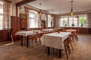 a dining room with tables and chairs and windows at Hotel Garni zum Schwan in Waldmünchen