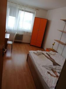 a bedroom with a bed and a red cabinet at Arena stožice rooms in Ljubljana