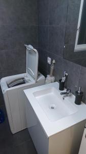 a bathroom with a sink and a washing machine at * Moulin Rouge Getaway * 1BR + Desk + Gym weights in Paris