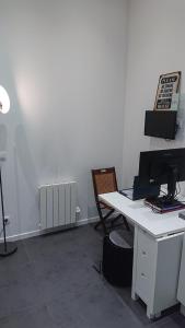 an office with a desk with a computer and a chair at * Moulin Rouge Getaway * 1BR + Desk + Gym weights in Paris