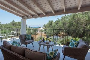 a patio with a couch and chairs and a table at Villa Helonaki in Kassiopi