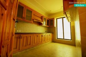 a kitchen with wooden cabinets and a window at Canari Hotel kashmir view in Nathia Gali