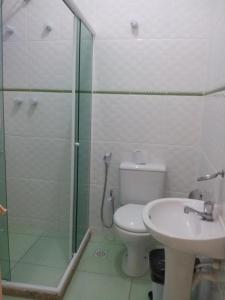 uma casa de banho com um chuveiro, um WC e um lavatório. em Pousada Caravela em Arraial do Cabo