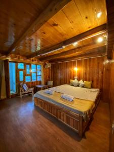 1 dormitorio con 1 cama grande en una habitación de madera en Pine Tower Inn, en Manali
