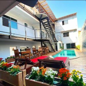 patio z krzesłami, basenem i budynkiem w obiekcie Pousada Caravela w mieście Arraial do Cabo