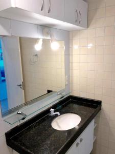 uma casa de banho com um lavatório e um espelho em FLATS VISTA MAR e FRENTE MAR NA PRAIA DOS CARNEIROS em Praia dos Carneiros