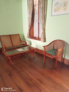 sala de estar con sofá, mesa y silla en Le Manoir en Antananarivo