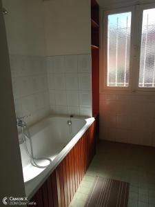 a bath tub in a bathroom with a window at Le Manoir in Antananarivo