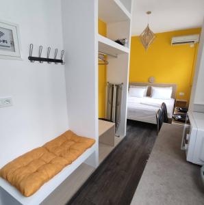 ein Zimmer mit einem Bett und ein Schlafzimmer mit gelben Wänden in der Unterkunft PETMEZA APARTMENT 2 by DIMITROPOULOS in Egio