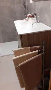 a bathroom with a sink and a towel chair at Casa vacanze Portigliatti: Elegante mansarda... in Cogne