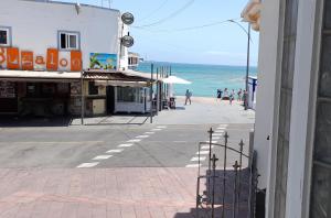 Une rue vide avec l'océan en arrière-plan dans l'établissement APARTAMENTO EN CORRALEJO, à Corralejo