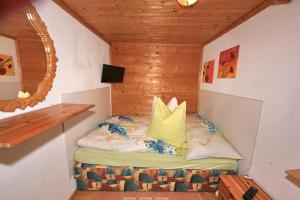 ein kleines Bett in einem Zimmer mit Spiegel in der Unterkunft Kuanerhof Wohnung 2-4 Personen in Ried im Zillertal