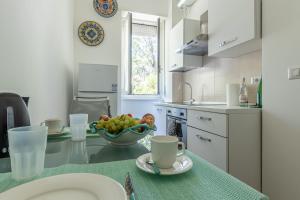 una cocina con una mesa con un bol de fruta. en CityLife, Fiera City, MiCo & San Siro Apartment, en Milán