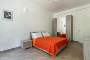 a bedroom with a bed with an orange blanket at CityLife, Fiera City, MiCo & San Siro Apartment in Milan