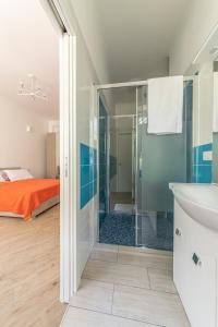 a bathroom with a glass shower and a bed at CityLife, Fiera City, MiCo & San Siro Apartment in Milan