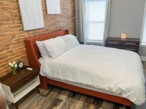a bedroom with a bed and a brick wall at Cozy Modern Apt in the Heart of Fells Point! in Baltimore