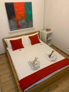 a bed with red and white pillows and a painting at Bologna Suite Centre City in Bologna