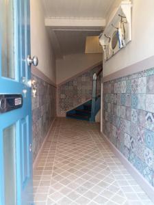 pasillo con suelo de baldosa y puerta azul en Casa Livia, en Lieser