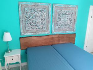 a blue bedroom with a bed with a wooden headboard at Casa Livia in Lieser