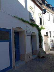 un edificio blanco con una puerta azul en una calle en Casa Livia, en Lieser