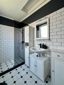 a white bathroom with a sink and a mirror at Fos and Flame in Sozopol