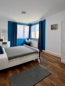 a bedroom with blue curtains and a bed with a rug at Fos and Flame in Sozopol