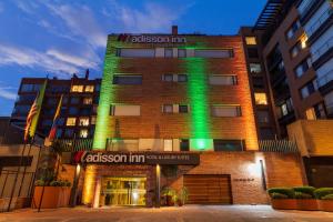 a building with a green light on the side of it at Hotel Madisson Inn Luxury By GEH Suites in Bogotá