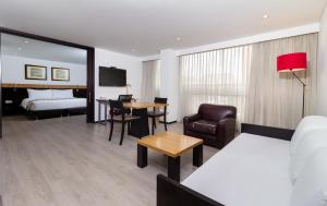 um quarto de hotel com uma cama e uma sala de estar em Hotel Madisson Inn Luxury By GEH Suites em Bogotá