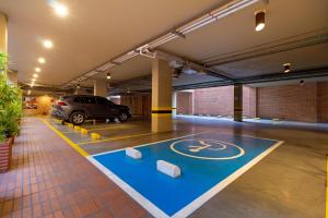 a parking garage with a blue floor with a bike lane at Hotel Madisson Inn Luxury By GEH Suites in Bogotá