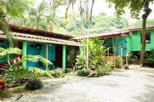 a house with a blue and green facade at Boutique Rooms at La Junta in Dominical