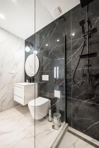 e bagno con servizi igienici e doccia in vetro. di Prime Star Fashion street modern luxury apartments a Budapest