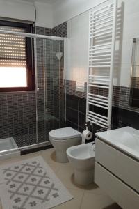 a bathroom with a toilet and a sink and a shower at Casa vacanza Sofy in Brindisi